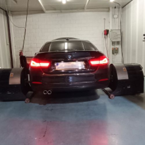 Coche BMW negro en cabina para reprogramación